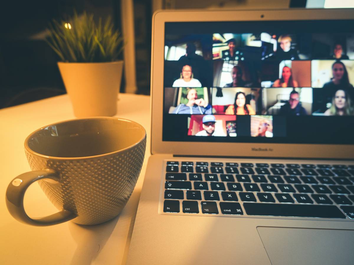 Introverted professional practicing professional job networking skills at a virtual event with notes and calm focus